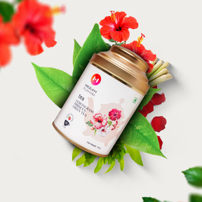 A tin of Health Platter Lemongrass Hibiscus Green Tea Wholeleaf Tea with a vibrant background of red flowers and green leaves.